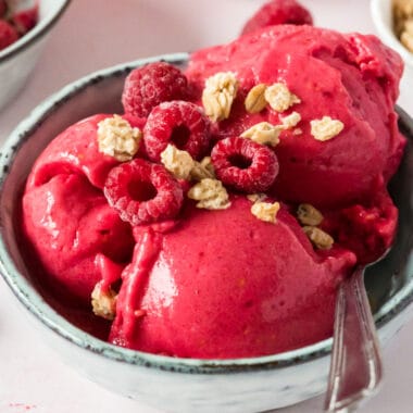 square image of 2-ingredient banana berry ice cream topped with granola and raspberries