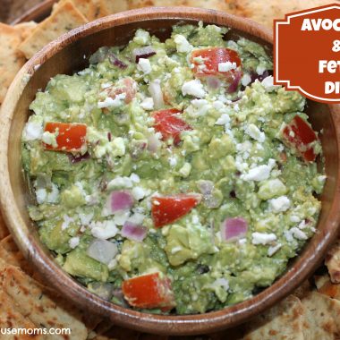 avocado and feta dip with crackers on a platter