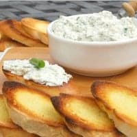 herbed ricotta bruschetta in a bowl with toasted bread slices