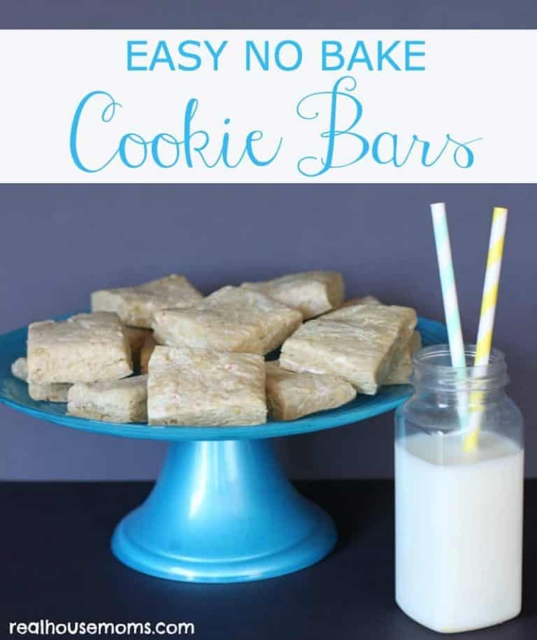 cookie bars on a blue cake stand with glass of milk