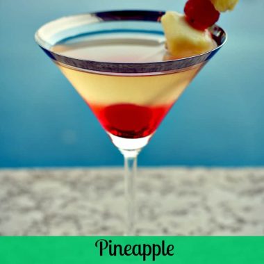 pineapple upside down cake martini in martini glass and fruit garnish