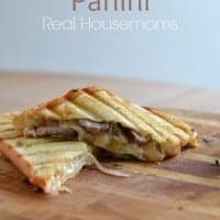 steak & onion panini on wooden cutting board