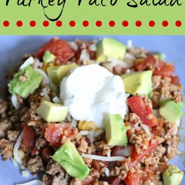 turkey taco salad topped with avocado and sour cream
