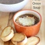 french onion soup in a ramekin with sliced baguette