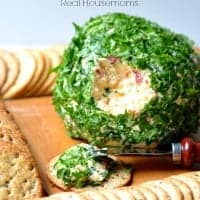 onion and bell pepper cheese ball on a cutting board with crackers