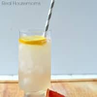 grapefruit tom collins in a glass with lemon slice and grapefruit wedge