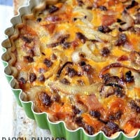 bacon sausage and cheddar quiche in a tart pan