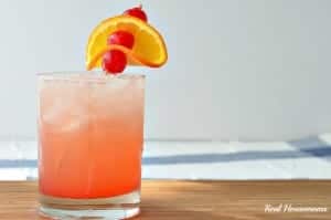 tropical sunset drink in a glass with fruit garnish
