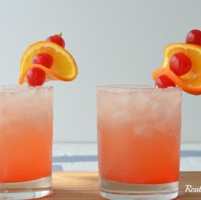 tropical sunset drink in a glass with fruit garnish