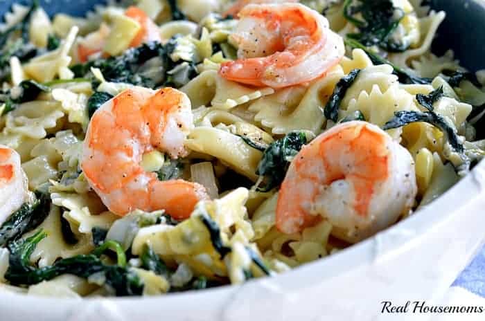 garlic roasted shrimp atop spinach artichoke pasta