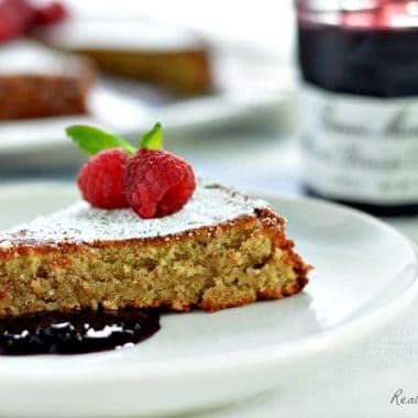 simple almond cake slice served with jelly and raspberries