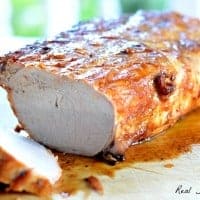 Grilled BBQ Pork Roast displayed on wooden cutting board