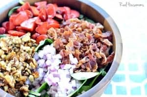 Spinach Bacon and Strawberry Salad displayed in a wooden sharing bowl