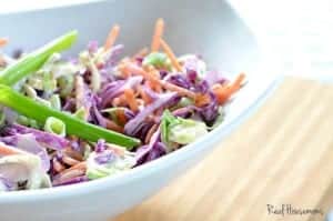 brussels sprouts, purple cabbage and carrot slaw served in a white sharing dish