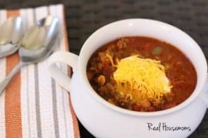 Easy weeknight chili feature displayed in a white sharing dish topped with sour cream and shreaded cheese
