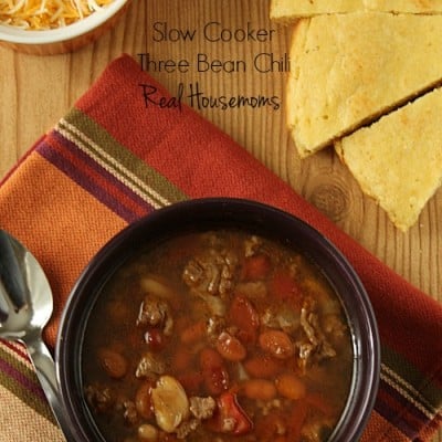 Slow Cooker Three Bean Chili displayed with a side of shreaded cheese