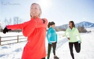 10 ways to stay active when the weather gets cold. Three women stretching in preparation for running