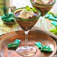 Andes Mint Martini served in a martini glass with green sugar on the rim. with a side of chocolate mint
