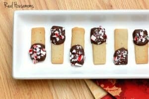 Holiday Chocolate Dipped Shortbread, shortbread dipped in chocolate topped with crushed candy cane served on a white serving dish