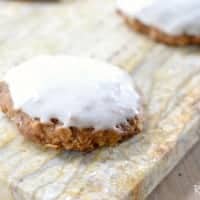 Pumpkin Oatmeal Cookies with Cream Cheese Icing served on a wood cutiing board