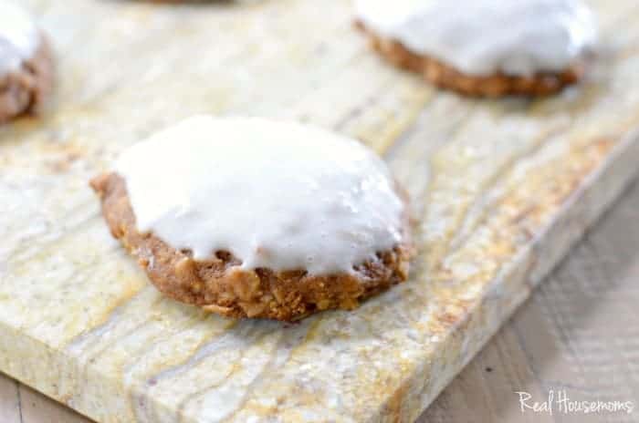 Pumpkin Oatmeal Cookies with Cream Cheese Icing served on a wood cutiing board