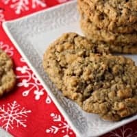 Spiced Oatmeal Raisin Cookies served on a white dish with a festive christmas table cloth in background