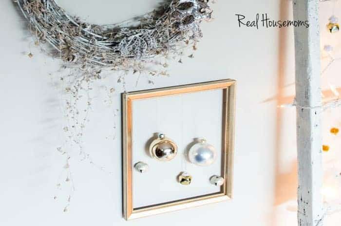 Christmas Tree Alternatives gold picture frame with silver and gold bulbs hanging in fram above frame is a silver wreath