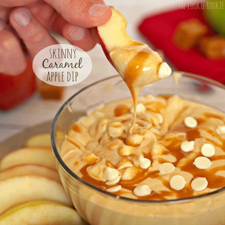 Skinny caramel apple dip, hand dipping apple slice in dip, Dip is topped with white chocolate pieces