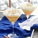 eggnog martini topped with whip cream served ina martini glass.photo shows two martinis on a serving tray