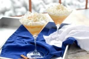 eggnog martini topped with whip cream served ina martini glass.photo shows two martinis on a serving tray