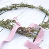 DIY Rosemary Wreaths, Rosemary branches arranged to make Wreath. Red and white bow on top of wreath