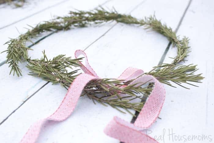 DIY Rosemary Wreaths, Rosemary branches arranged to make Wreath. Red and white bow on top of wreath