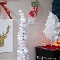 Glitter Reindeer Canvas. White Canvas with a gold glitter reindeer on canvas. red bow at the top of Canvas to hang from wall