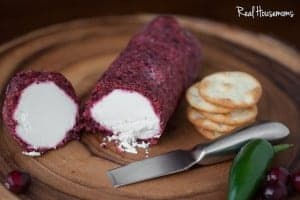 Jalapeño Cranberry Cheese Log cut in half with a side of crackers
