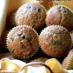 Banana Chocolate Chip Coconut Muffins. four muffins sitting in bread basket with yellow cloth lining
