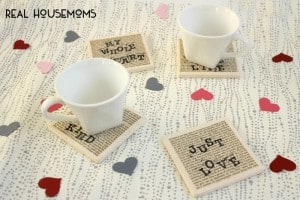 DIY Love Quote Coasters, Four coasters with very tiny writing as background and larger writting on top each coater has it's own quote, two of the four coasters have white mugs on them