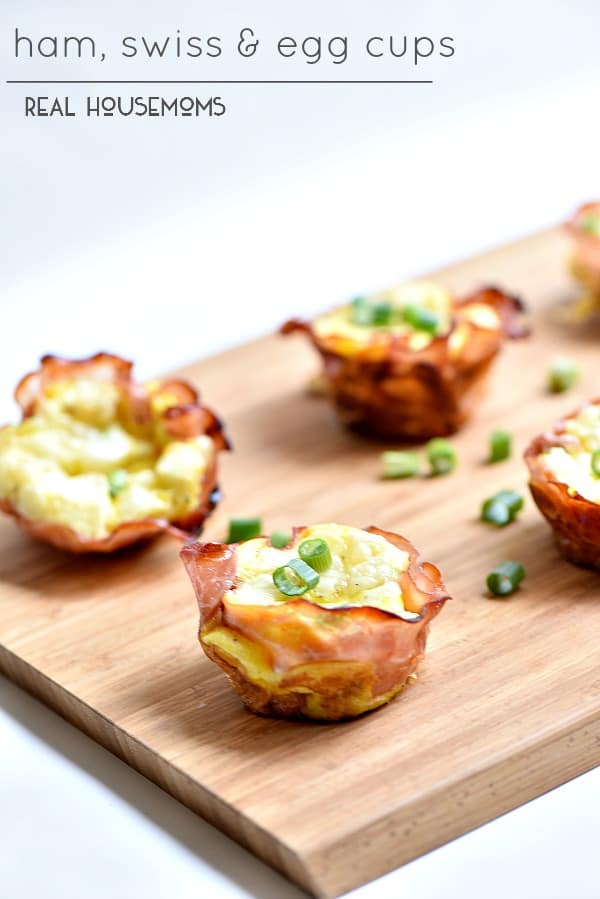 Ham Swiss and Egg cups topped with chives served on a cutting board