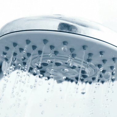 The easy way to get rid of hair clogs in your shower. close up of running shower head