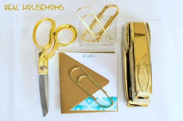 creating an inspirational workspace. All gold Office supplies Scissors, paper clis, Stapler, hello note with gold envalope