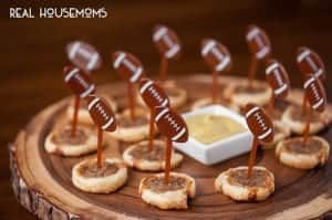Three Ingredient Sausage Roll Bites. Topped with little football cupcake toppers, served with a side of dijon mustard