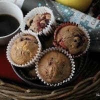 Chocolate Berry Muffins. wicker basket filled with hot coffee, apple, magazine, and juice