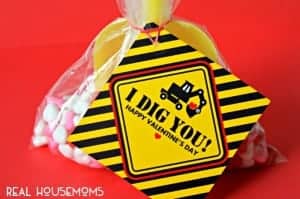 "I Dig You" Valentine with free print. Printables that read "I DIG YOU HAPY VALENTINE DAY" with a Excavators digger machine, yellow, black and red colors Printable attached to a goodie bag with a yelow toy shovel