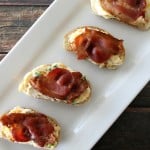 Jalapeno Popper Bruschetta. Served on minni bread topped with bacon. served on a white serving tray