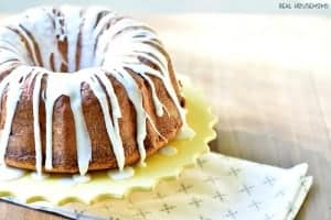 Lemon Pound Cake. Drizzled with white frosting displayed on a round yellow vake stand