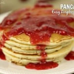 Pancakes with Easy Raspberry Sauce. Sick Pancakes stacked served on a large white plate.