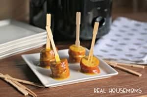 Slow Cooker Honey Mustard Kielbasa Bites. served on a white serving dish with minni wooden forks