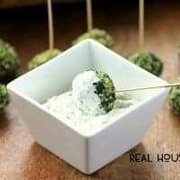 Spinach Balls with panko crumbs served with a side of lemon dip. Toothpicks at the top of the spinach balls for easy grabbing