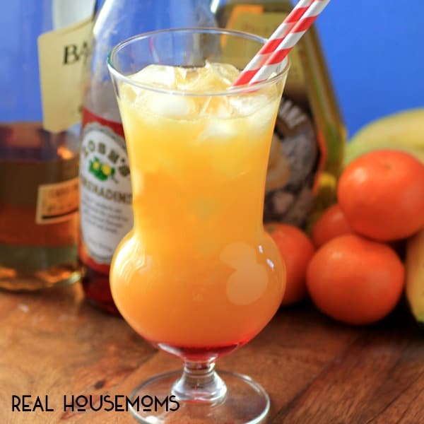 Tropical Breeze Cocktail. Orange cocktail over ice served with a white and red straw