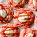 Strawberry Lemonade Cheesecake Cookies on a plate with a glaze drizzled on top.
