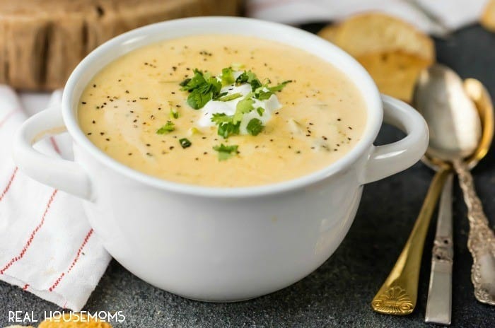 Slow Cooker Broccoli Cheese Soup in a soup bowl topped with sour cream and parsley